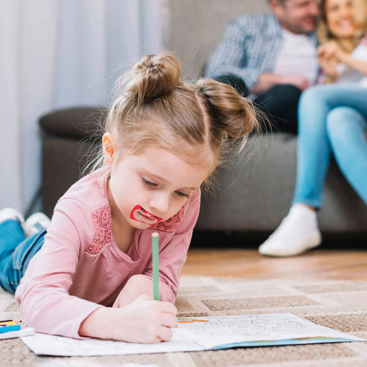 Young girl writing while using myotape's mouth tape for kids. Mouth Breathing and Crooked Teeth