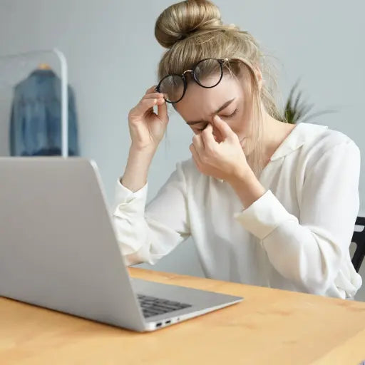 Tired woman working on her desk with an open laptop. Nasal Congestion Reduces Cognitive Function