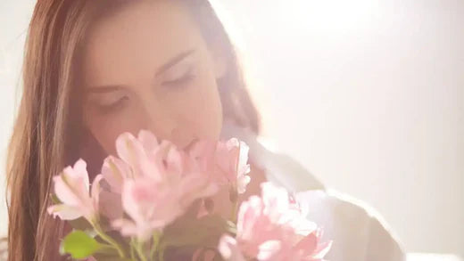 Woman smelling flowers. The Intriguing Science Behind Smell and Partner Choice